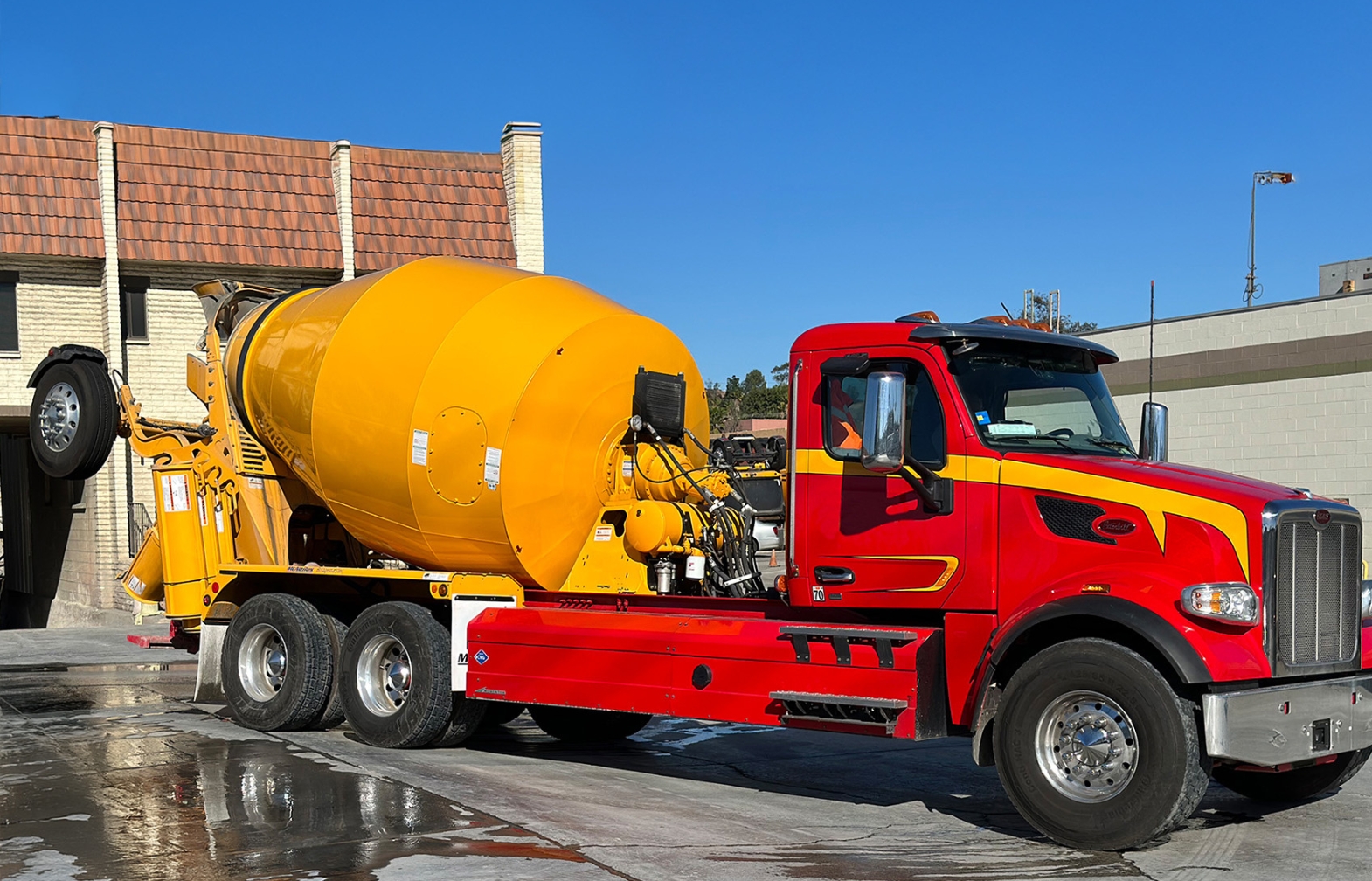 Red Peterbilt day cab truck with yellow mixer body and side mount CNG fuel system